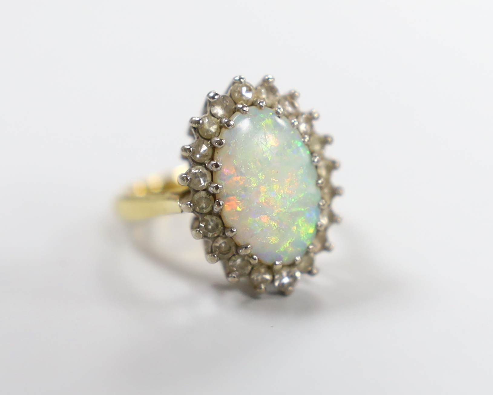 An 18ct, white opal and diamond set oval cluster ring, size L, gross weight 6.6 grams.